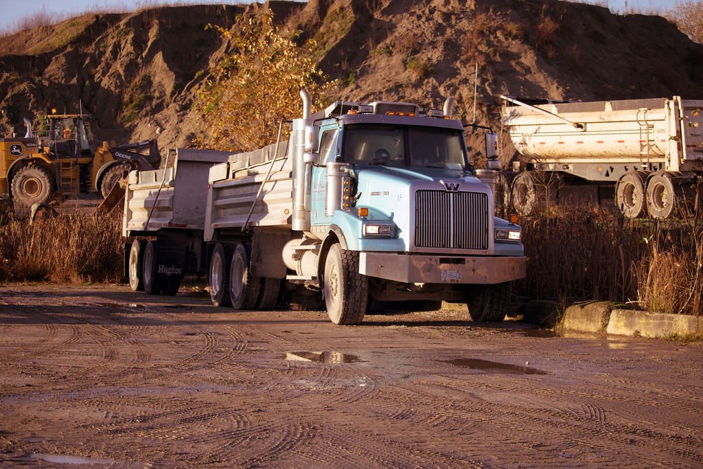 Hughes Trucking equipment and hauling services on site.